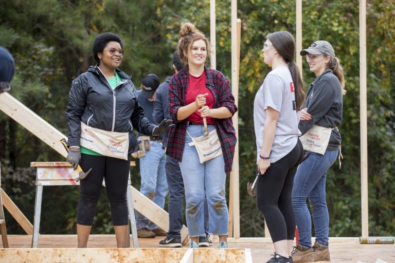 Students in Habitat for Humanity talking on a build site
